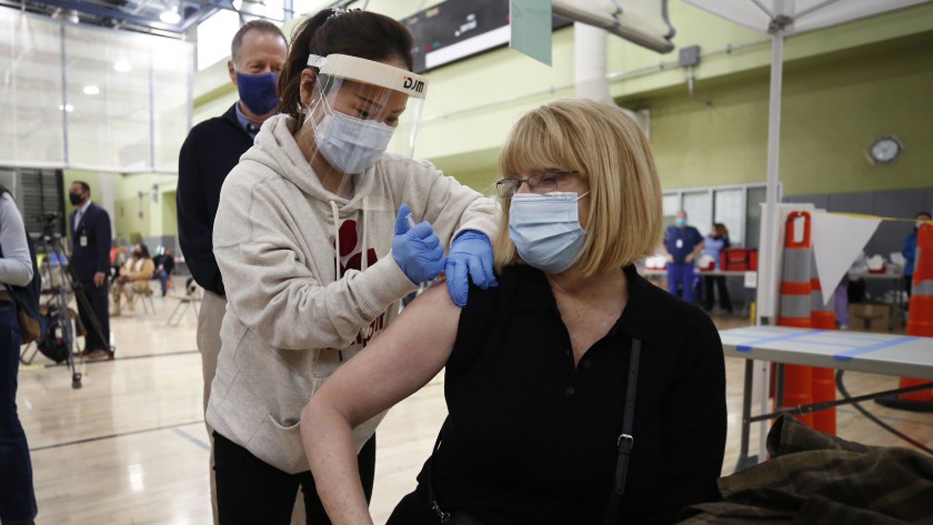 Pacoima Middle School teacher Abigail Abbott, 65, gets her COVID-19 vaccination from nurse practitioner Jiyoun Cho at the Roybal Learning Center in Echo Park on Feb. 17, 2021. (Al Seib / Los Angeles Times)