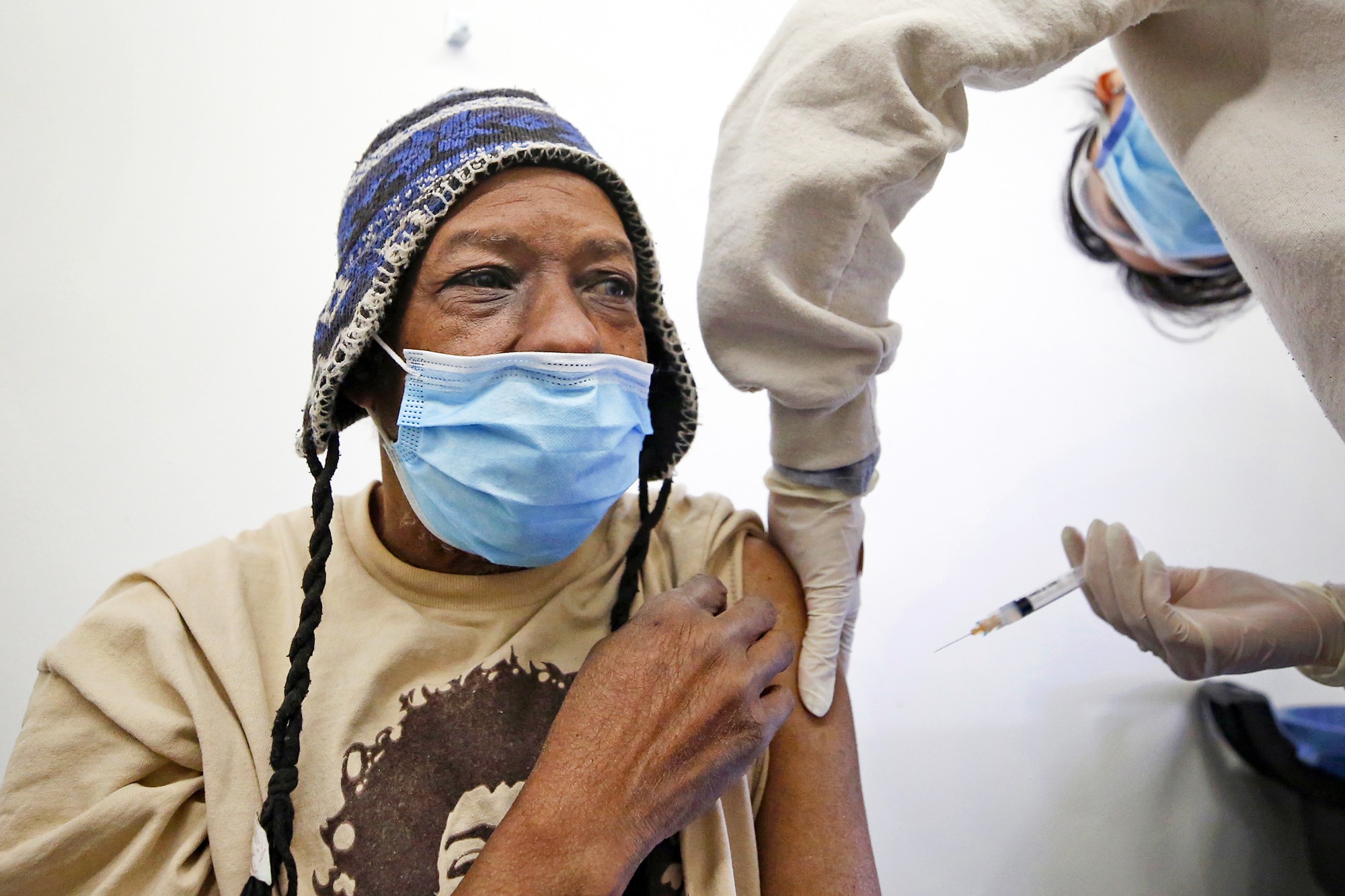 Lance Curtis, 65, receives a COVID-19 vaccination from registered nurse Katherine Han at Los Angeles Christian Health Centers — Joshua House Clinic on Winston Street in the skid row area of downtown Los Angeles.(Al Seib / Los Angeles Times)