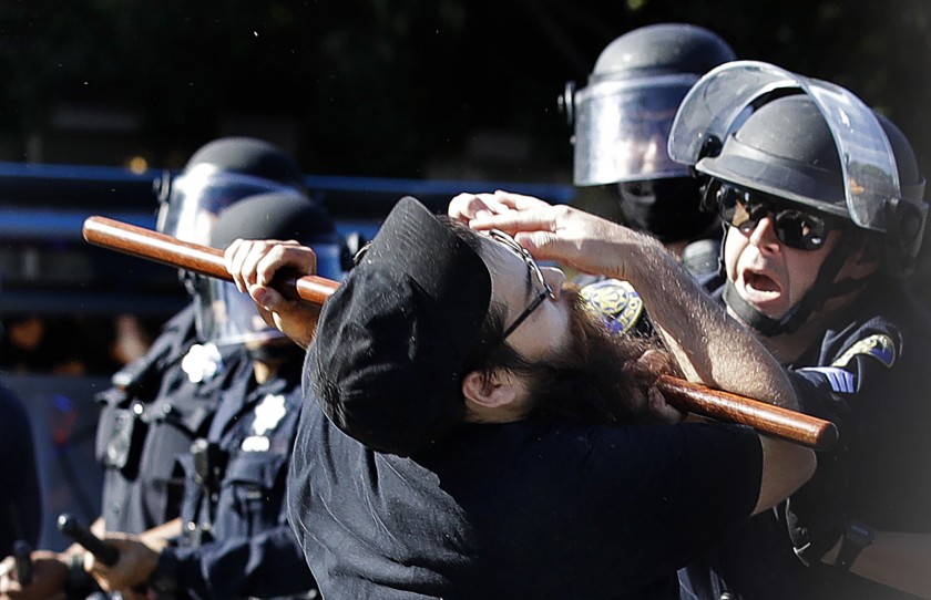 In this May 29, 2020, photo, a protester is hit with a baton by San Jose police, during a demonstration over the death of George Floyd. (AP Photo/Ben Margot, File)