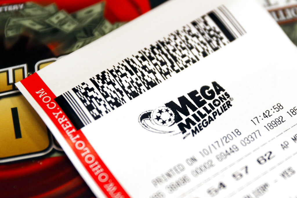 In this Oct. 17, 2018, file photo a Mega Millions lottery ticket rests on the shop counter at the Street Corner Market in Cincinnati. (AP Photo/John Minchillo, File)