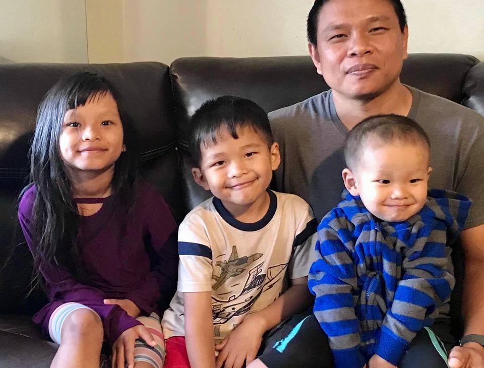 This undated photo provided by Bawi Cung, shows Bawi Cung, right, seated with his children at home, before he and his two sons were stabbed in an anti-Asian attack last March 2020 at Sam's Club in Midland, Texas. (Bawi Cung via AP)