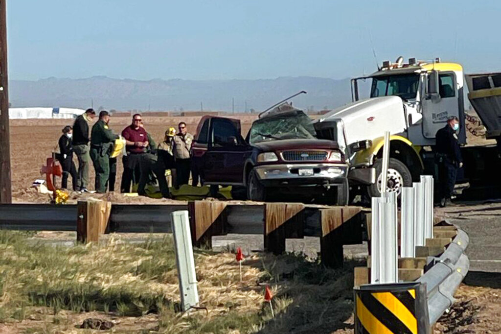 Authorities work at the scene of a deadly crash involving a semitruck and an SUV in Holtville, near the California border with Mexico, on March 2, 2021. (KYMA via Associated Press)