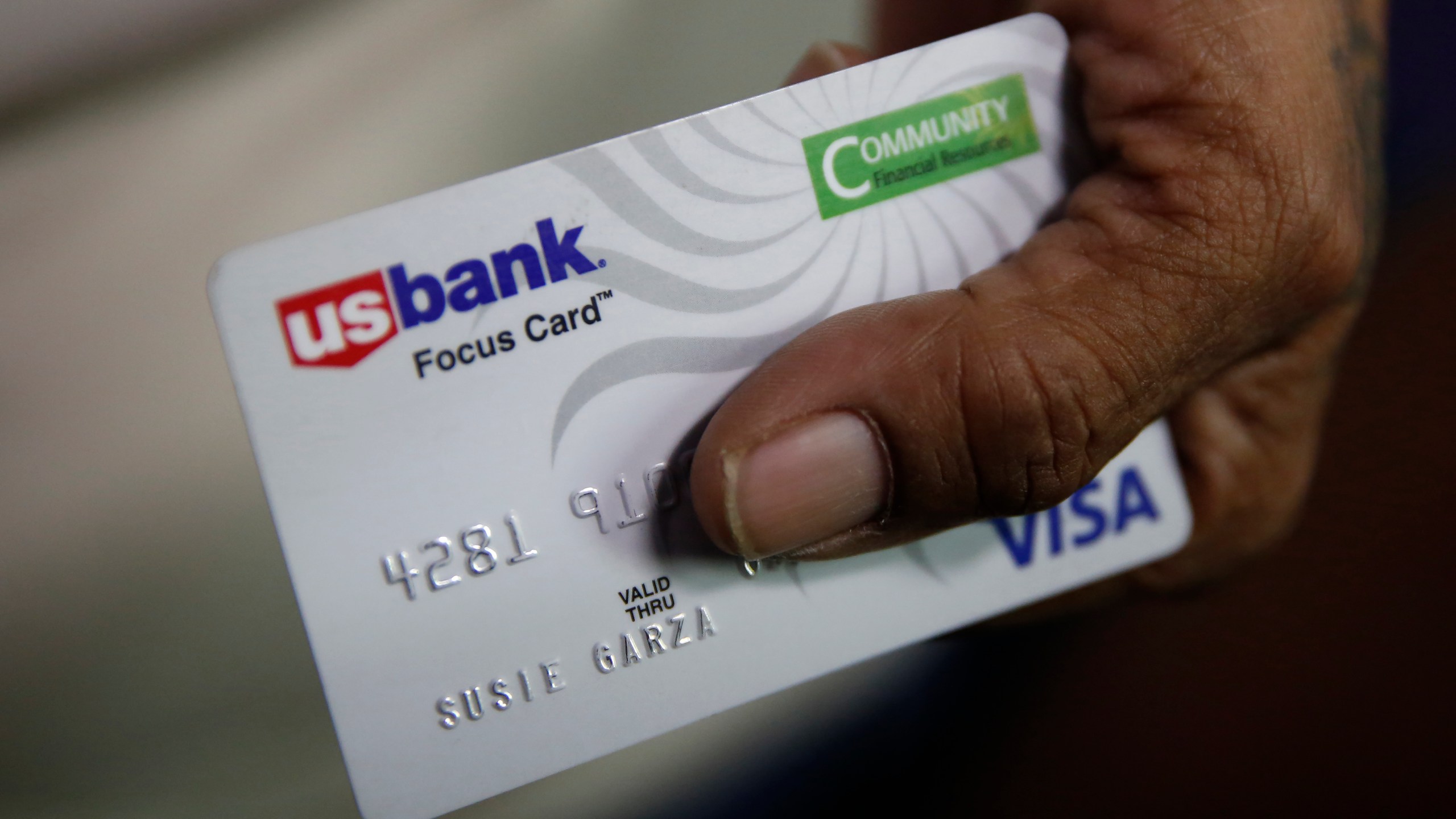 In this Aug. 14, 2019, file photo, Susie Garza displays the city provided debit card she receives monthly through a trial program in Stockton, Calif. A study of people in California who received $500 a month for free says they used it to pay off debt and get full-time jobs. A pair of independent researchers reviewed data from the first year of the study and released their finding on Wednesday, March 3, 2021. (AP Photo/Rich Pedroncelli, File)