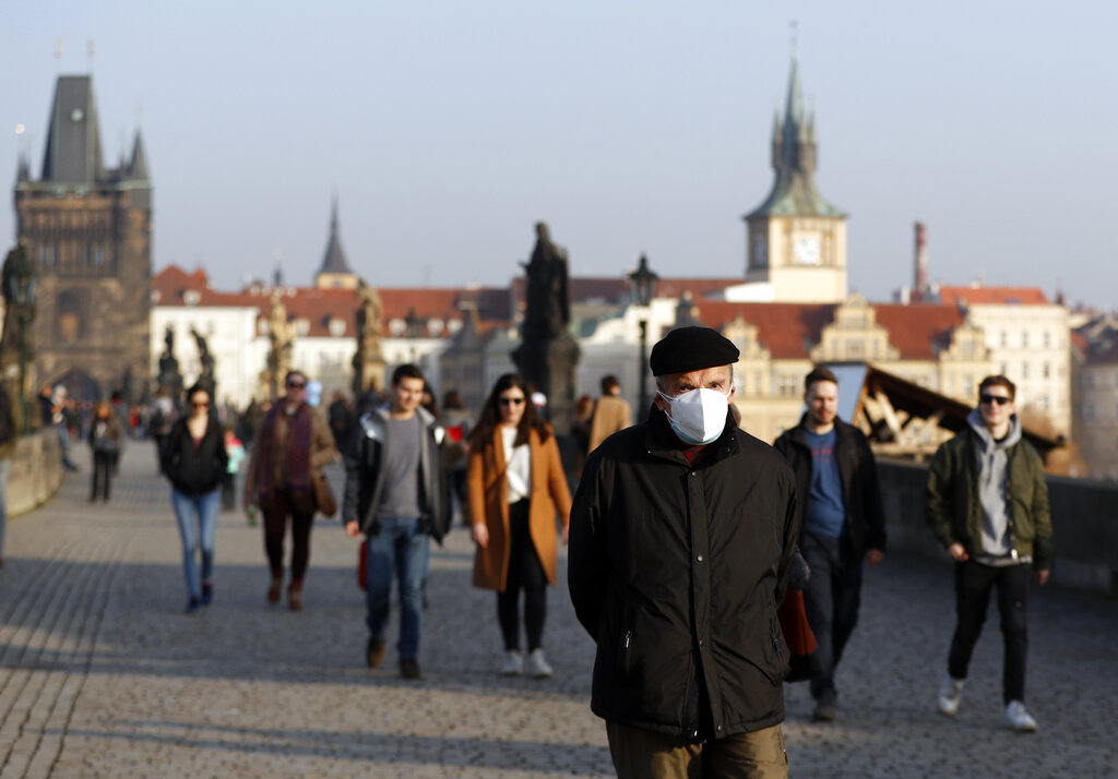 In this Thursday, Feb. 25, 2021 file photo, a man wearing a face mask walks across the medieval Charles Bridge in Prague, Czech Republic. (AP Photo/Petr David Josek, File)