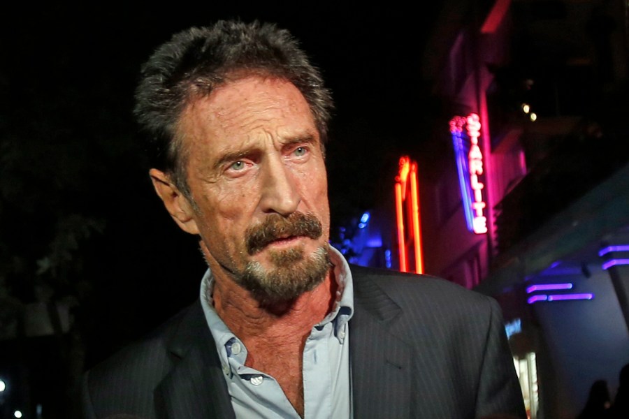 In this Dec. 12, 2012 file photo, anti-virus software founder John McAfee answers questions to reporters as he walks on Ocean Drive, in the South Beach area of Miami Beach, Fla. (AP Photo/Alan Diaz, File)