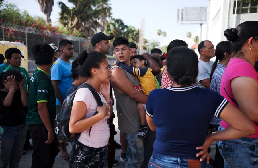 In this July 31, 2019 file photo, migrants line up in Matamoros, Mexico, for a meal donated by volunteers from the U.S., at the foot of the Puerta Mexico bridge that crosses to Brownsville, Texas. (AP Photo/Emilio Espejel, File)