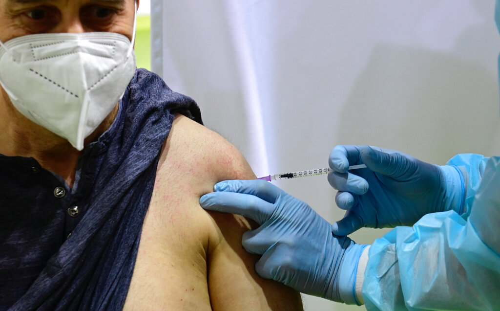 In this March 8, 2021 file photo, German police officer Dirk Moeller gets an AstraZeneca vaccination against Covid-19 at a new vaccination centre at the former Tempelhof airport in Berlin, Germany. (Tobias Schwarz / Pool via AP, File)