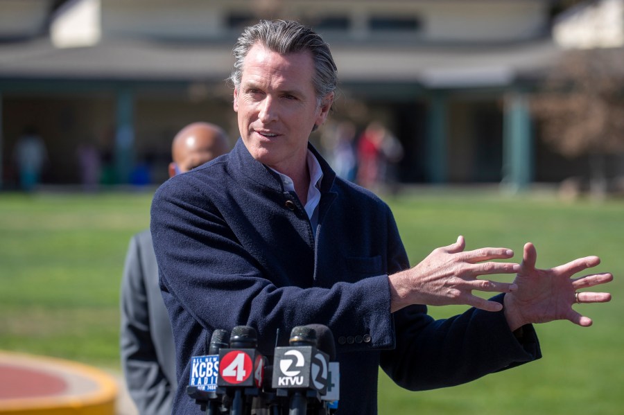 California Gov. Gavin Newsom speaks about the state's plan to reopen schools as coronavirus vaccinations continue during a news conference on the schoolyard at Barron Park Elementary in Palo Alto on March 2, 2021. (Karl Mondon / Bay Area News Group via Associated Press)