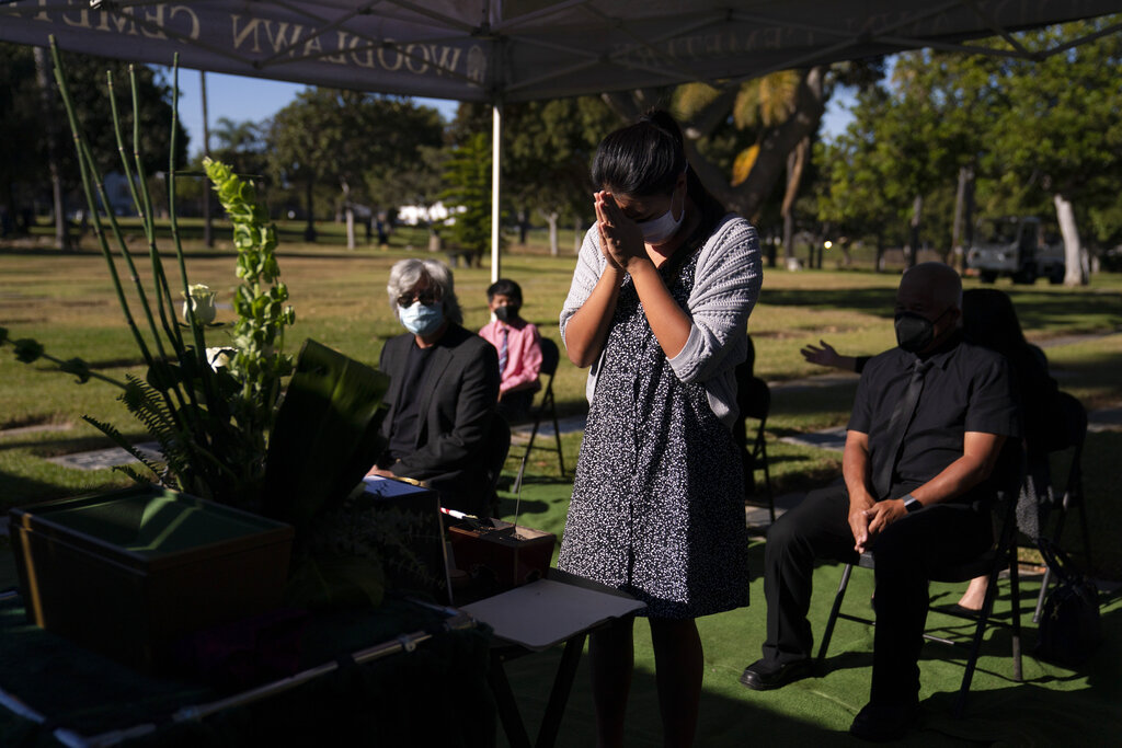 Lilah Matsumura, 11, prays for for her great-grandfather, Giichi Matsumura, during a memorial service at Woodlawn Cemetery in Santa Monica, Calif., Monday, Dec. 21, 2020. (AP Photo/Jae C. Hong)