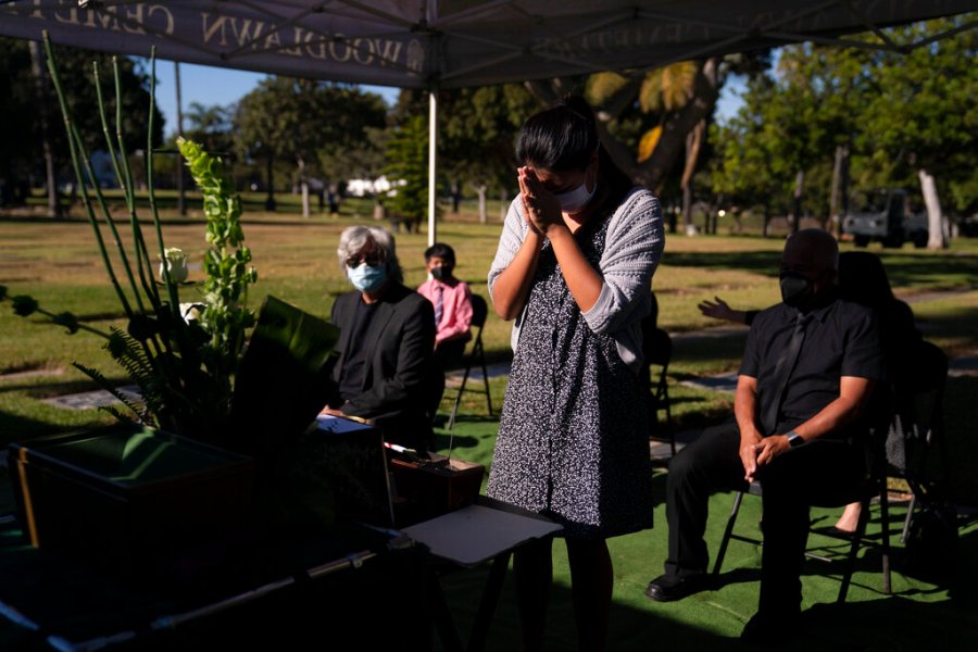 Lilah Matsumura, 11, prays for for her great-grandfather, Giichi Matsumura, during a memorial service at Woodlawn Cemetery in Santa Monica, Calif., Monday, Dec. 21, 2020. (AP Photo/Jae C. Hong)