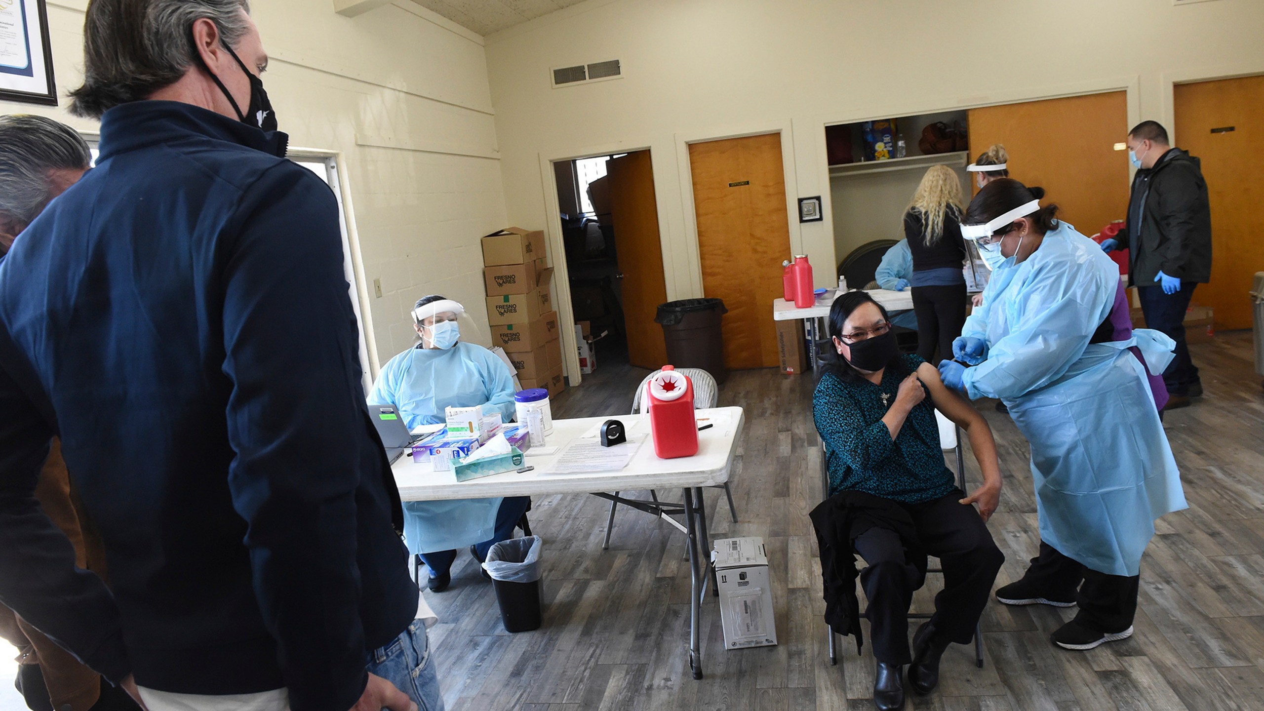 California Gov. Gavin Newsom watches as a farmworker receives the Pfizer COVID-19 vaccine at a vaccination clinic for farmworkers in Fresno on Feb. 26, 2021. (John Walker / The Fresno Bee via Associated Press)