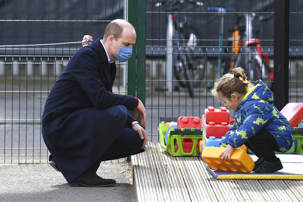 Britain's Prince William watches a child in the playground during a visit with Kate, Duchess of Cambridge to School21, a school in east London, Thursday March 11, 2021. (Justin Tallis/Pool via AP)