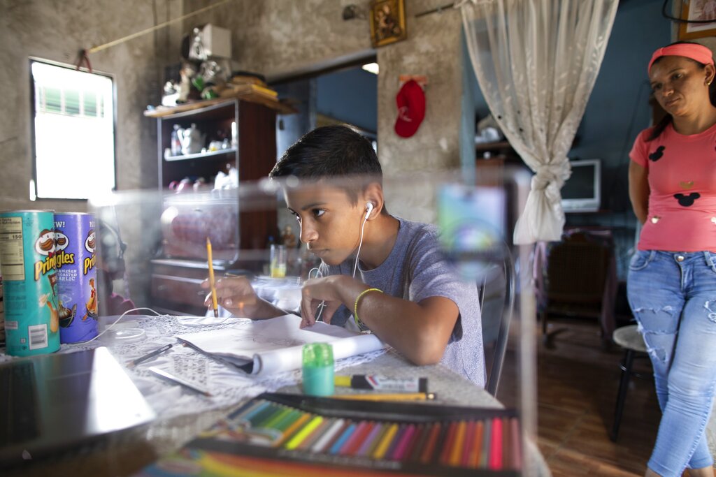 Samuel Andres Mendoza looks at a picture of a Pokemon on his computer before drawing it, at his home in Barquisimeto, Venezuela, Tuesday, March 2, 2021. (AP Photo/Ariana Cubillos)