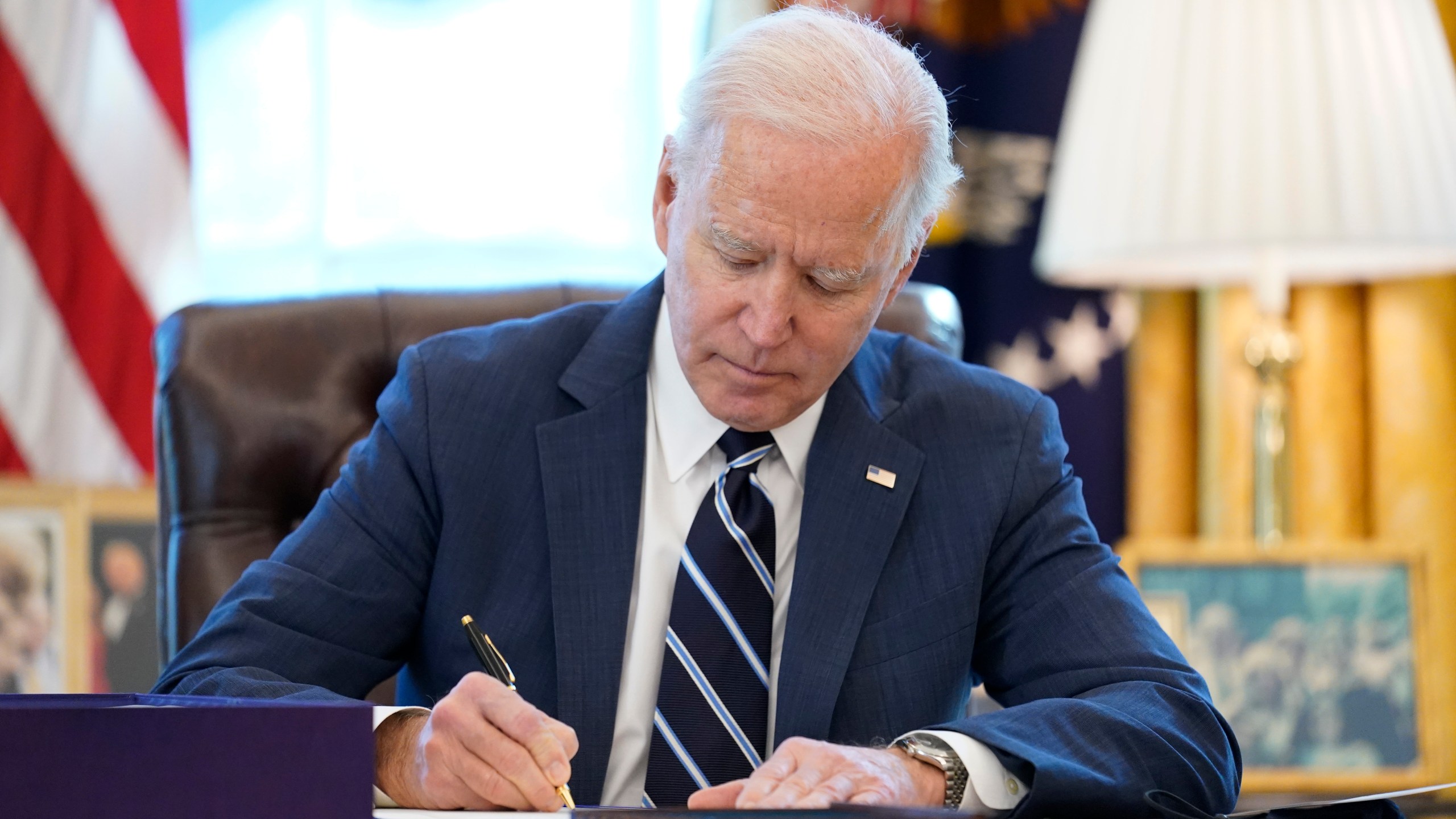 President Joe Biden signs the American Rescue Plan, a coronavirus relief package, in the Oval Office of the White House, Thursday, March 11, 2021, in Washington. (AP Photo/Andrew Harnik)