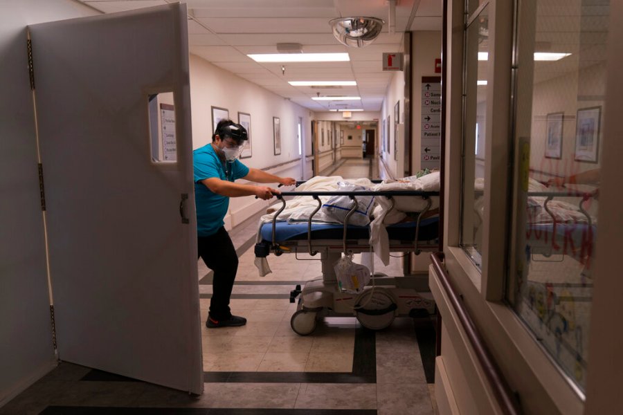 In this Friday, Feb. 19, 2021, file photo, medical transporter Adrian Parrilla moves a patient into a COVID-19 unit at Mission Hospital in Mission Viejo, California. (AP Photo/Jae C. Hong, File)