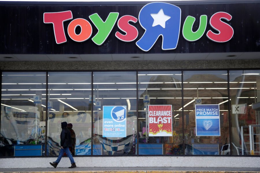 In this Jan. 24, 2018, file photo, a person walks near the entrance to a Toys R Us store, in Wayne, N.J. (AP Photo/Julio Cortez, File)