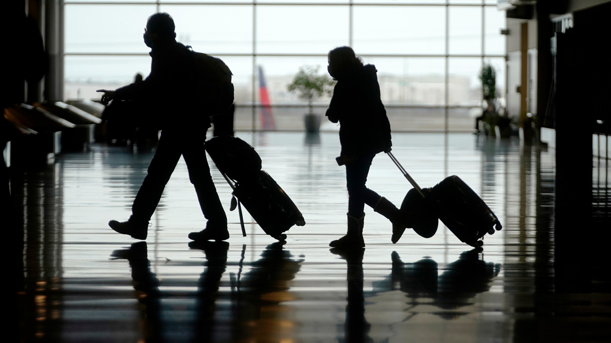 In this Tuesday, March 9, 2021 file photo, travelers walk through the Salt Lake City International Airport, in Salt Lake City. (AP Photo/Rick Bowmer, File)