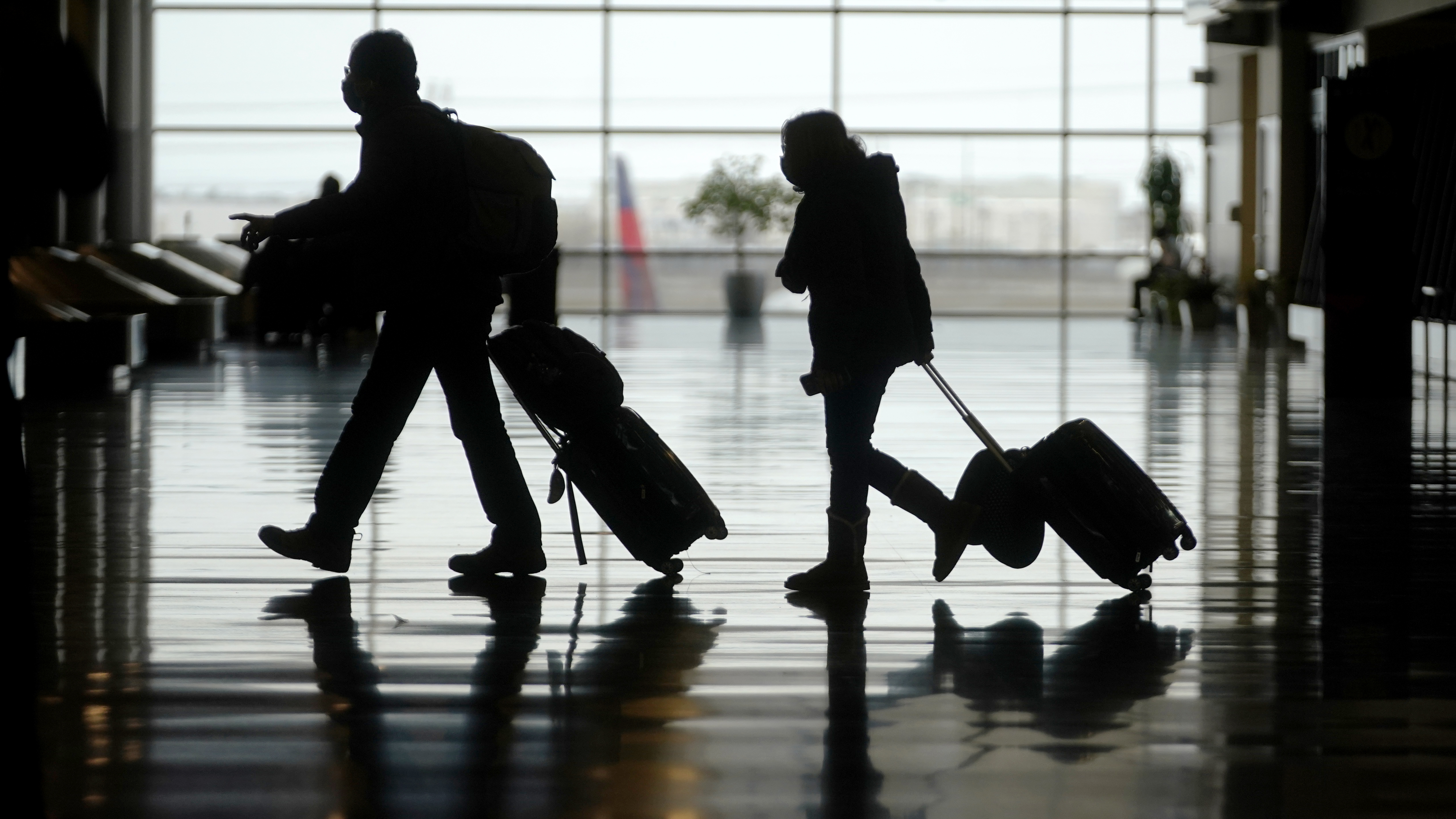 In this Tuesday, March 9, 2021 file photo, travelers walk through the Salt Lake City International Airport, in Salt Lake City. (AP Photo/Rick Bowmer, File)