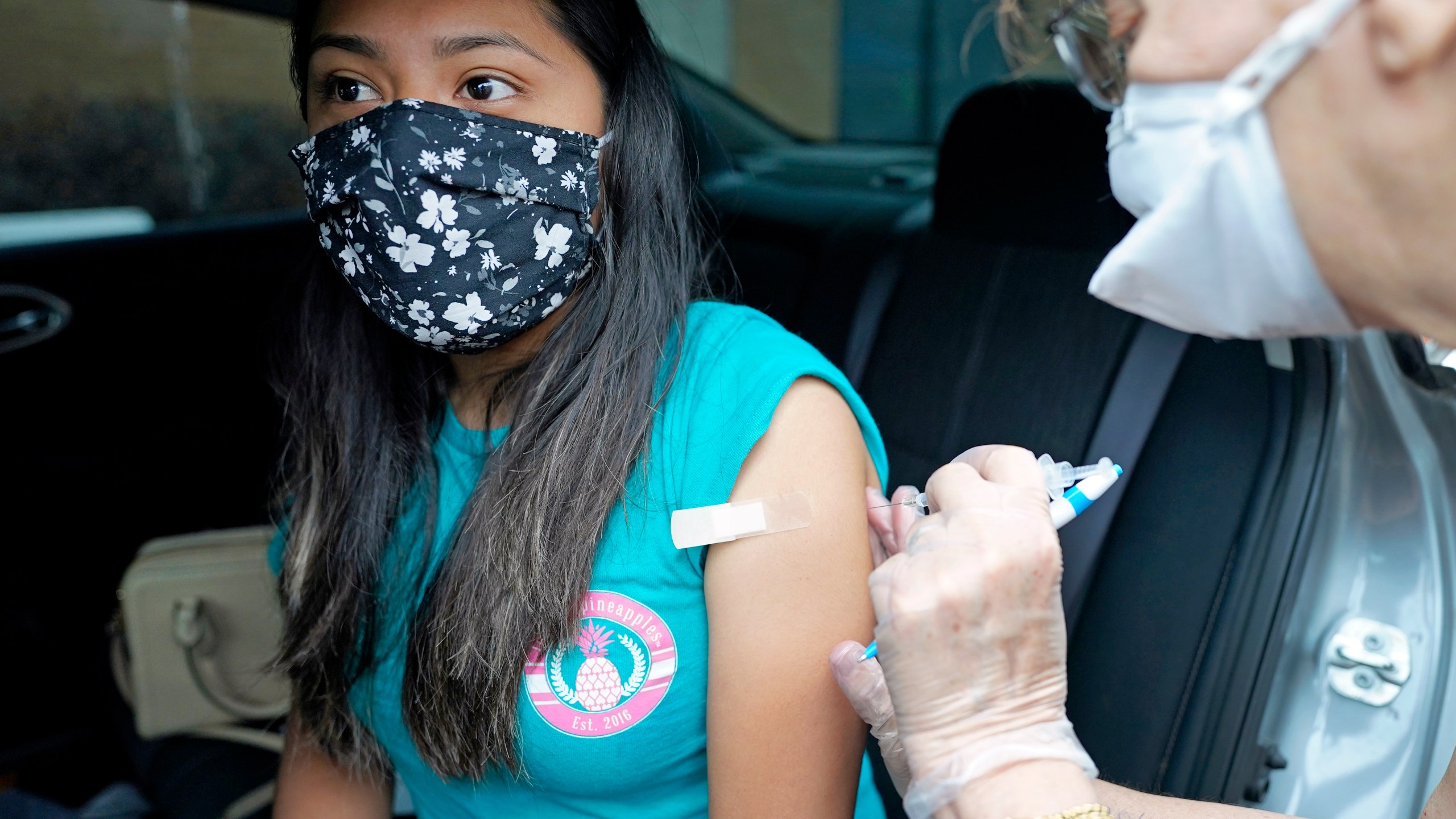 Jennifer Lira, left, a childcare specialist in the Spring Branch Independent School District, receives a Pfizer COVID-19 vaccination shot from nurse Carolyn Roy during a vaccination drive for education workers Tuesday, March 16, 2021, in Houston. (AP Photo/David J. Phillip)