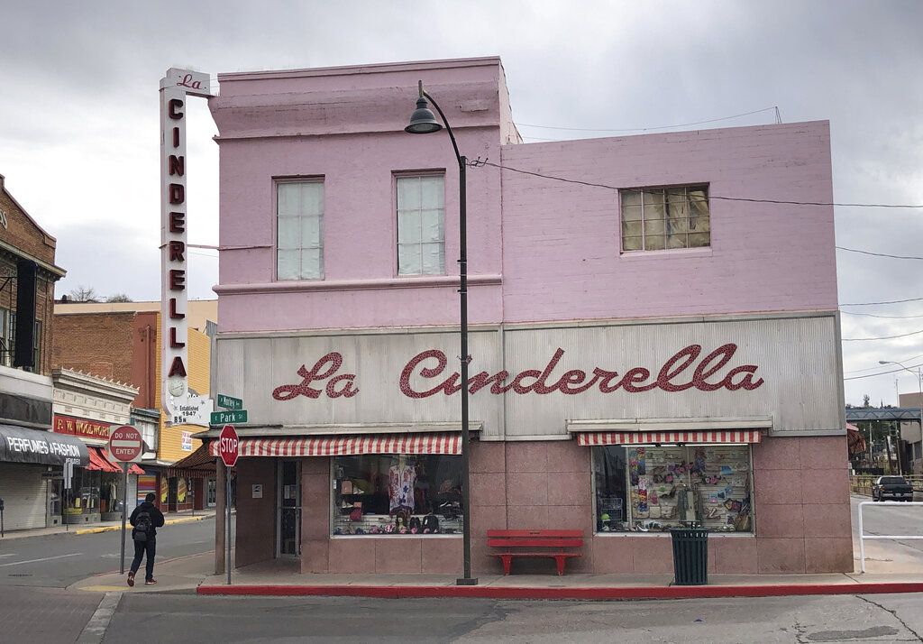 A man walks past a shuttered clothing store in the border town of Nogales, Arizona on March 15, 2021. The store has been in business for nearly half a century but closed because of the pandemic for almost a year, with its main customer base, Mexican day-trippers, largely unable to come to the U.S. and shop. (AP Photo/Suman Naishadham)