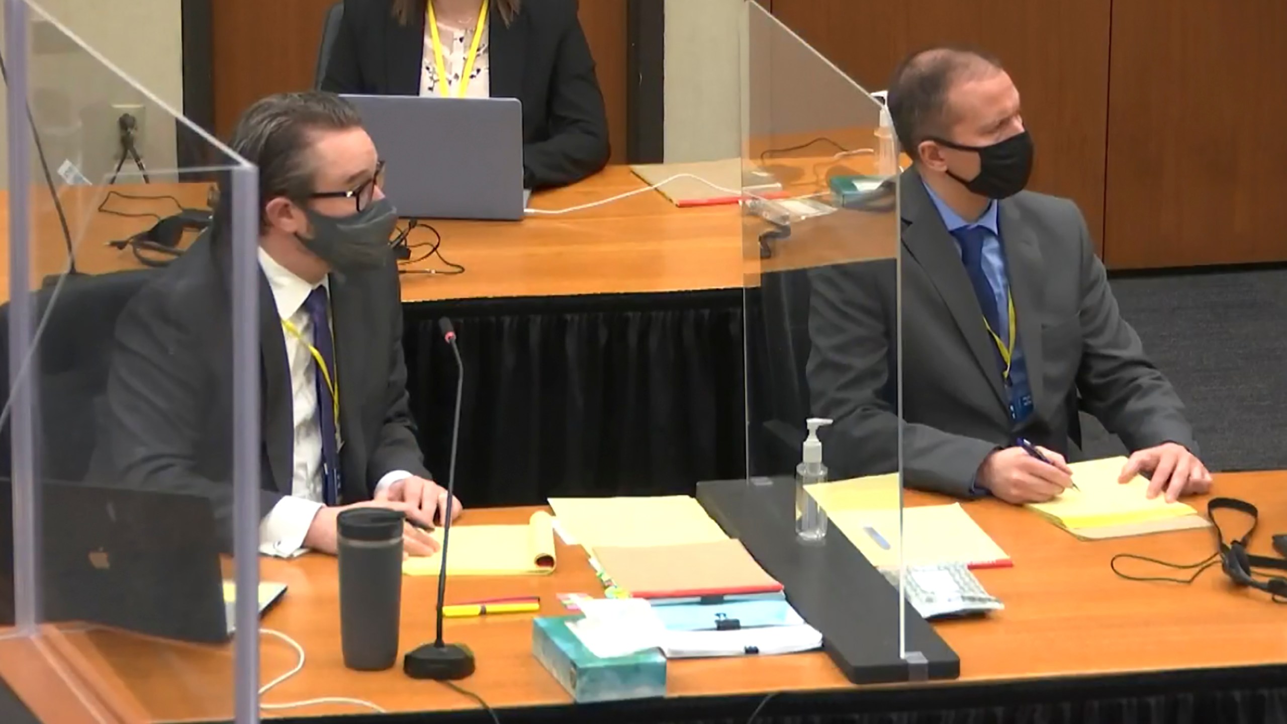 In this screen grab from video, defense attorney Eric Nelson, left, and defendant and former Minneapolis police officer Derek Chauvin, right, listen as Hennepin County Judge Peter Cahill discusses pre-trial motions, prior to continuing jury selection, Friday, March 19, 2021, at the Hennepin County Courthouse in Minneapolis, Minn. (Court TV via AP, Pool)