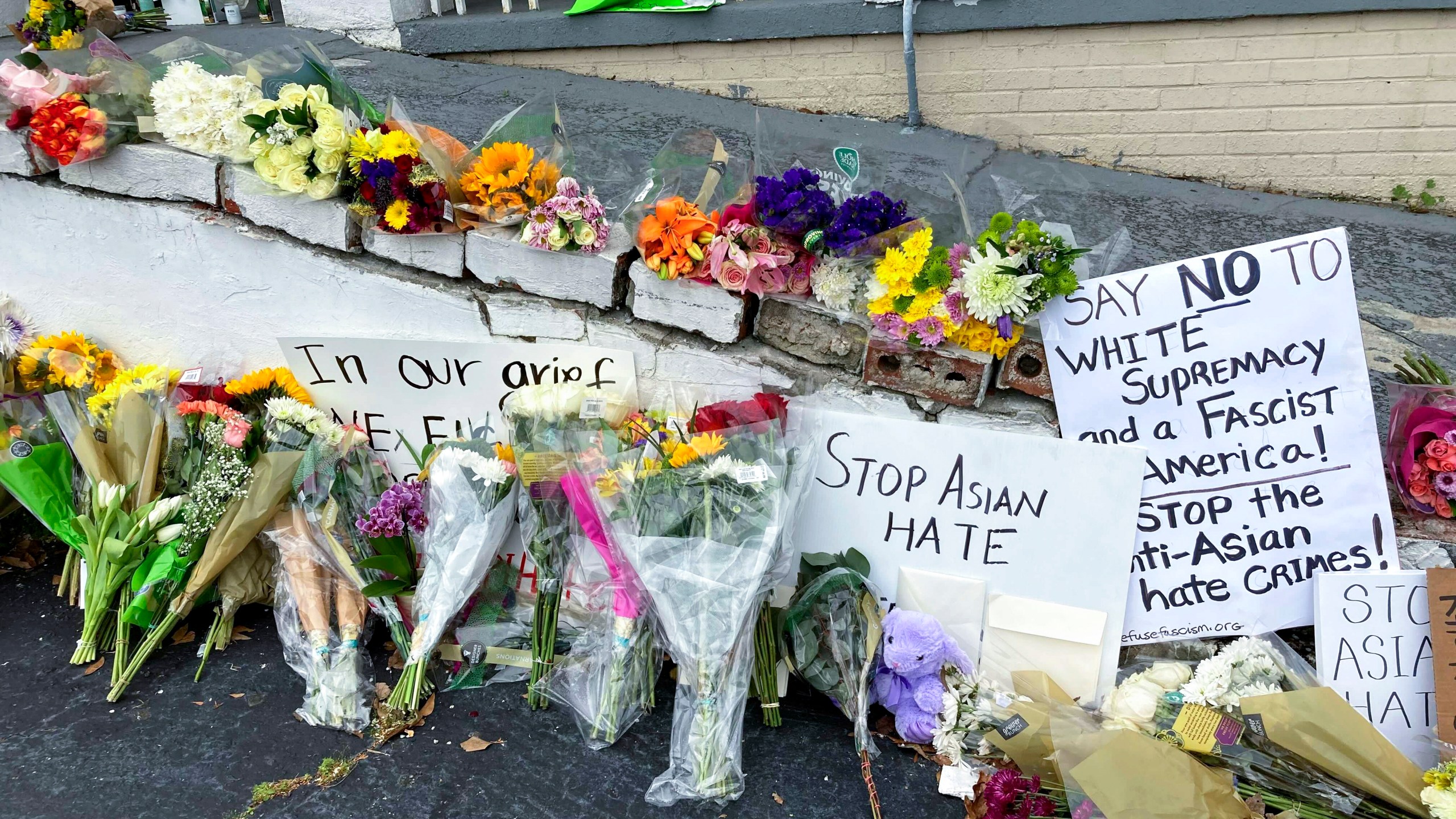 Flowers, candles and signs are displayed at a makeshift memorial on Friday, March 19, 2021, in Atlanta. Robert Aaron Long, a white man, is accused of killing several people, most of whom were of Asian descent, at massage parlors in the Atlanta area. (AP Photo/Candice Choi)