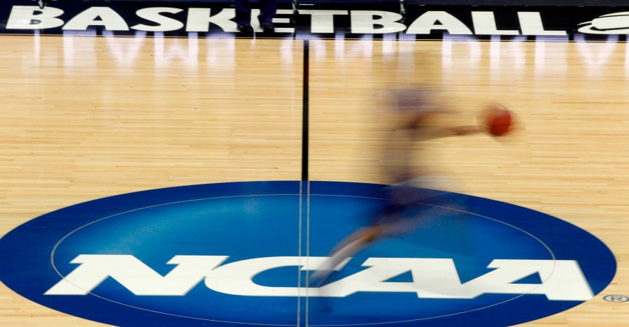 In this March 14, 2012, file photo, a player runs across the NCAA logo during practice in Pittsburgh before an NCAA tournament college basketball game. (AP Photo/Keith Srakocic, File)