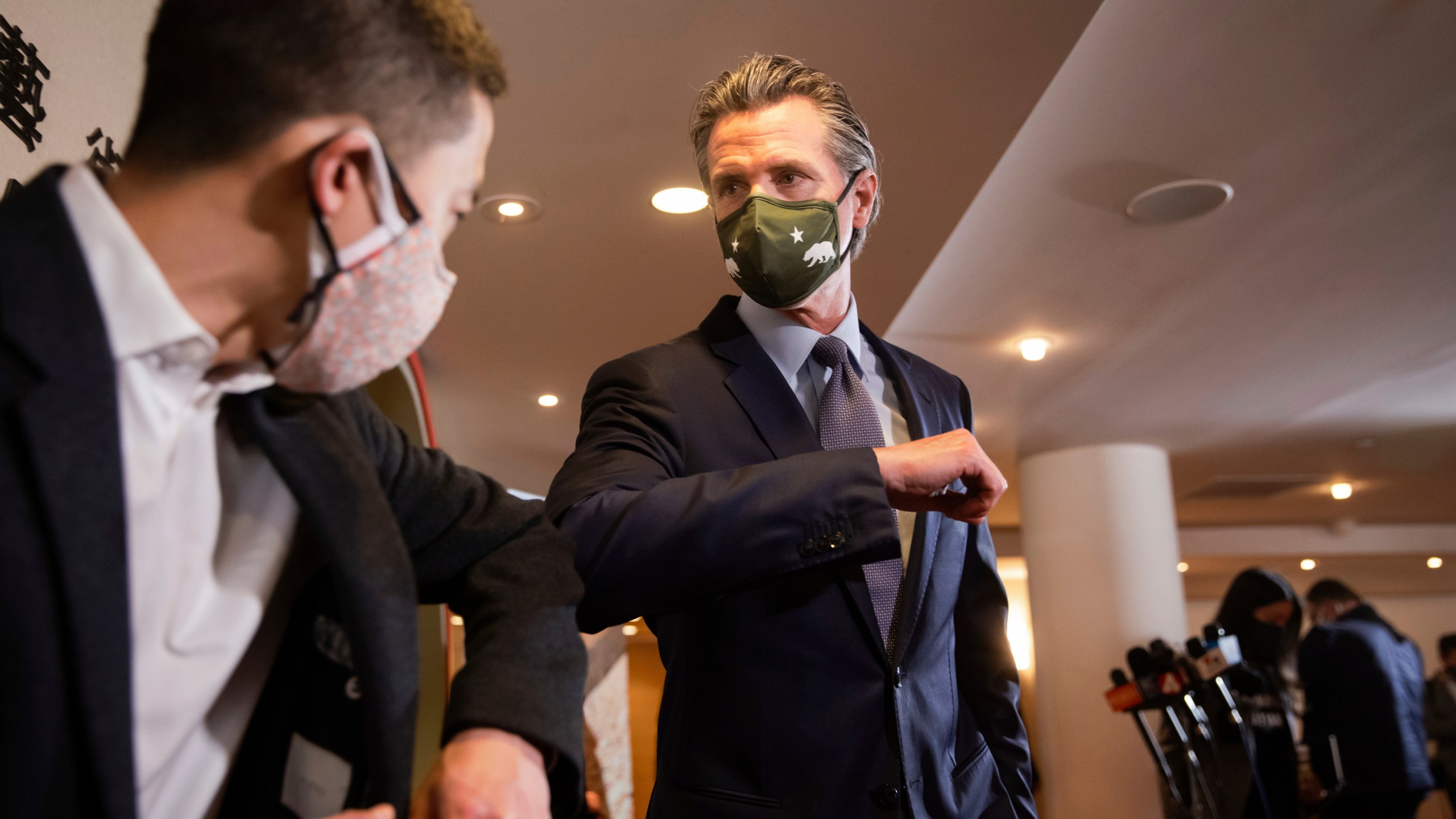 California Gov. Gavin Newsom, center, bumps elbows with Eddie Ahn, Executive Director of the environment justice non-profit, Brightline Defense, after a news conference with Bay Area Asian American and Pacific Islander community leaders amid the rise in racist attacks across the country in San Francisco, Friday, March 19, 2021. (Dai Sugano/Bay Area News Group via AP)