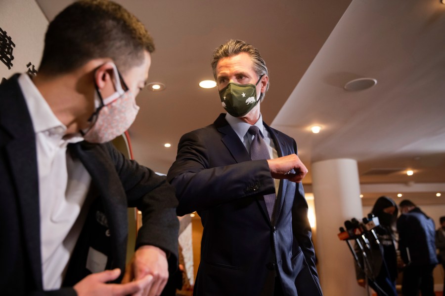 California Gov. Gavin Newsom, center, bumps elbows with Eddie Ahn, Executive Director of the environment justice non-profit, Brightline Defense, after a news conference with Bay Area Asian American and Pacific Islander community leaders amid the rise in racist attacks across the country in San Francisco, Friday, March 19, 2021. (Dai Sugano/Bay Area News Group via AP)