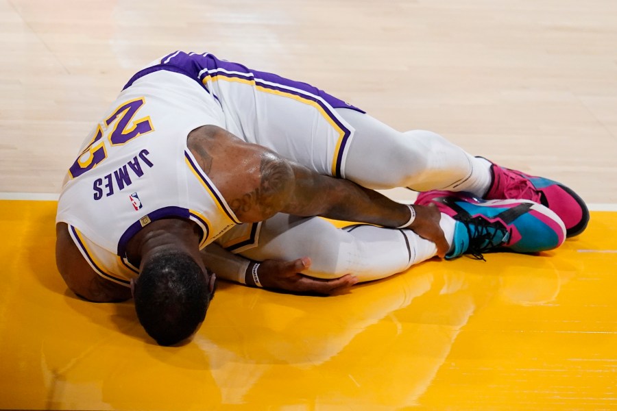 Los Angeles Lakers forward LeBron James holds his ankle after going down with an injury during the first half of an NBA basketball game against the Atlanta Hawks on March 20, 2021, in Los Angeles. (AP Photo/Marcio Jose Sanchez)