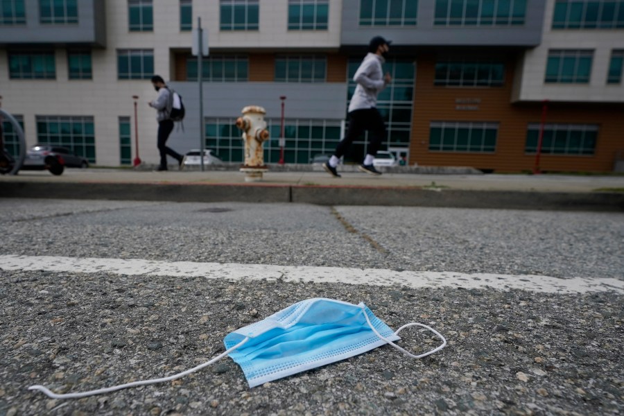 A discarded face mask lies in the street in San Francisco on March 17, 2021. (AP Photo/Jeff Chiu)