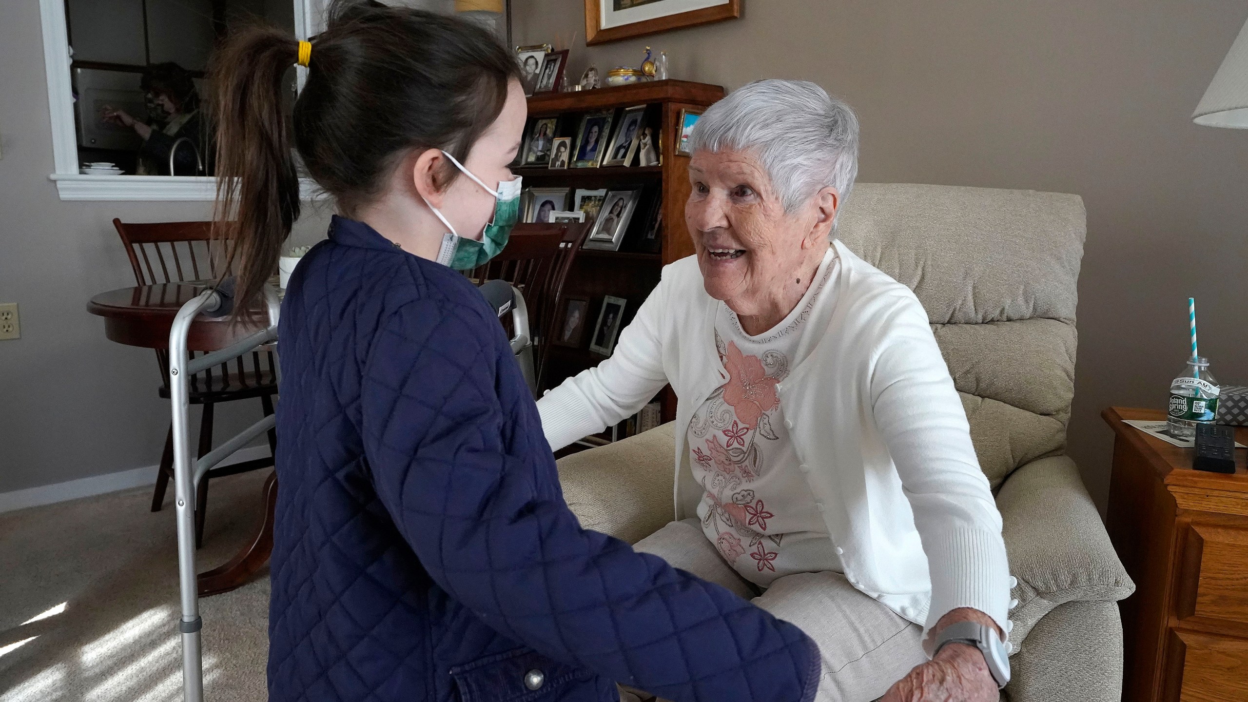 Eileen Quinn, 98, right, a resident at New Pond Village retirement community in Walpole, Mass., greets her great-granddaughter Maeve Whitcomb, 6, at the retirement community in Walpole on March 21, 2021. (Steven Senne/Associated Press)