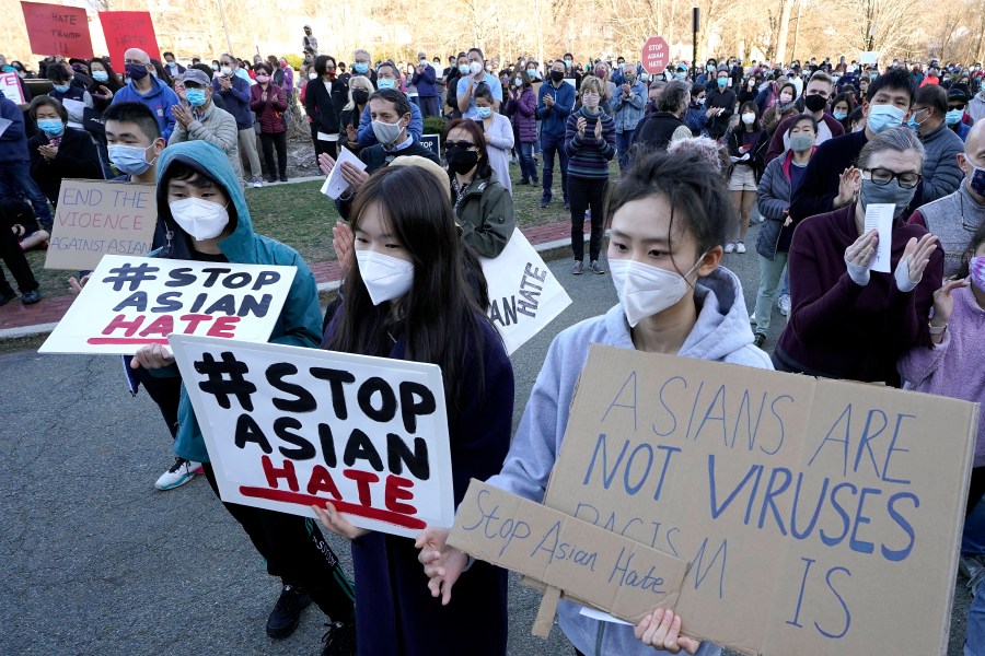 Protesters display placards during a rally held to support Stop Asian Hate, Sunday, March 21, 2021, in Newton, Massachusetts. (AP Photo/Steven Senne)