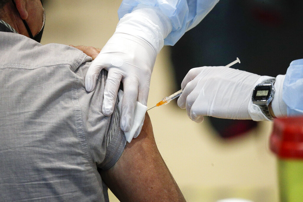 In this Friday, March 19, 2021 file photo Medical staff members administer the AstraZeneca vaccine at La Nuvola (The Cloud) convention center that was temporarily turned into a COVID-19 vaccination hub, in Rome. (AP Photo/Gregorio Borgia)