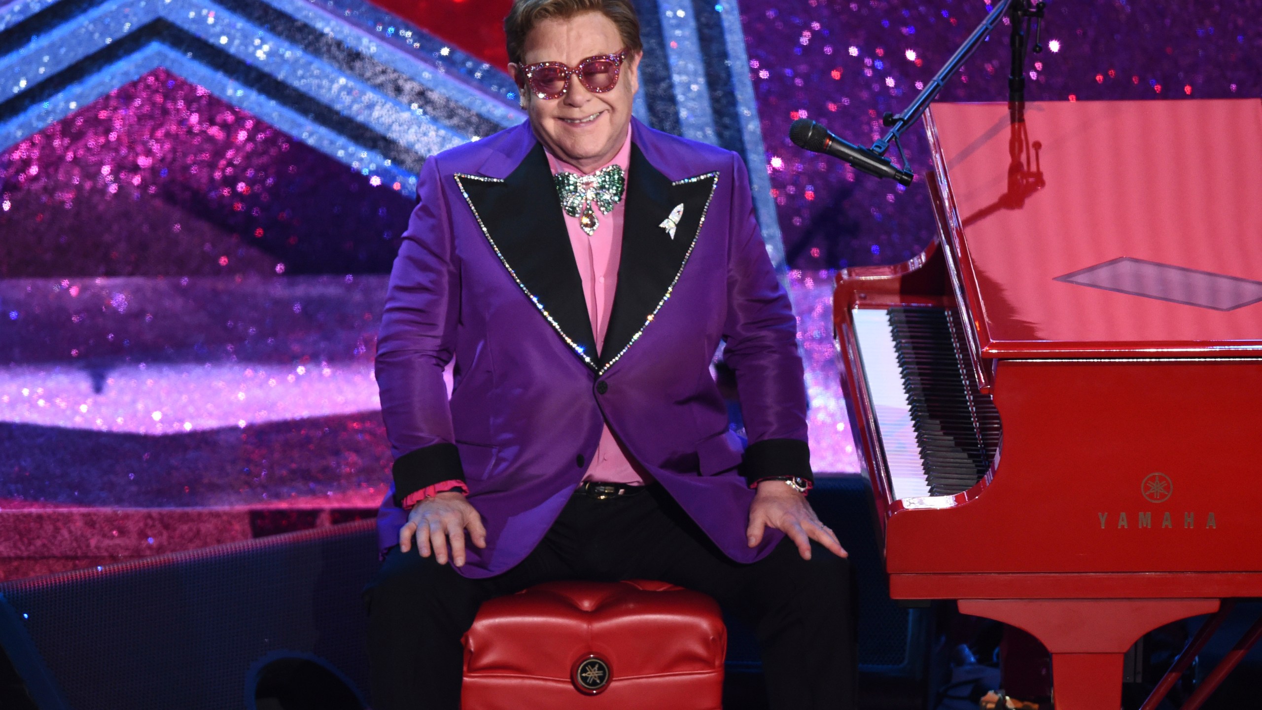 In this Sunday, Feb. 9, 2020, file photo, Elton John appears after performing his nominated song, "(I'm Gonna) Love Me Again," at the Oscars in Los Angeles. Attending Elton John’s long-running Oscar-night party has always been one of the hardest tickets to get. Now you can go — if you have $20. The Elton John AIDS Foundation is inviting everyone to a hour-long, virtual pre-show Oscar party special hosted by Neil Patrick Harris and with a performance by Dua Lipa. Tickets for the April 25 event are $19.99 and are available via Ticketmaster. Proceeds will go to young people at risk and living with HIV all over the world. (AP Photo/Chris Pizzello, File)