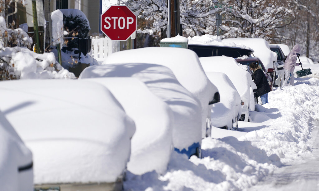 In this Monday, March 15, 2021 file photo, snow covers vehicles parked along Second Avenue after a powerful late winter storm dumped more than 2 feet of snow in Denver. (AP Photo/David Zalubowski)