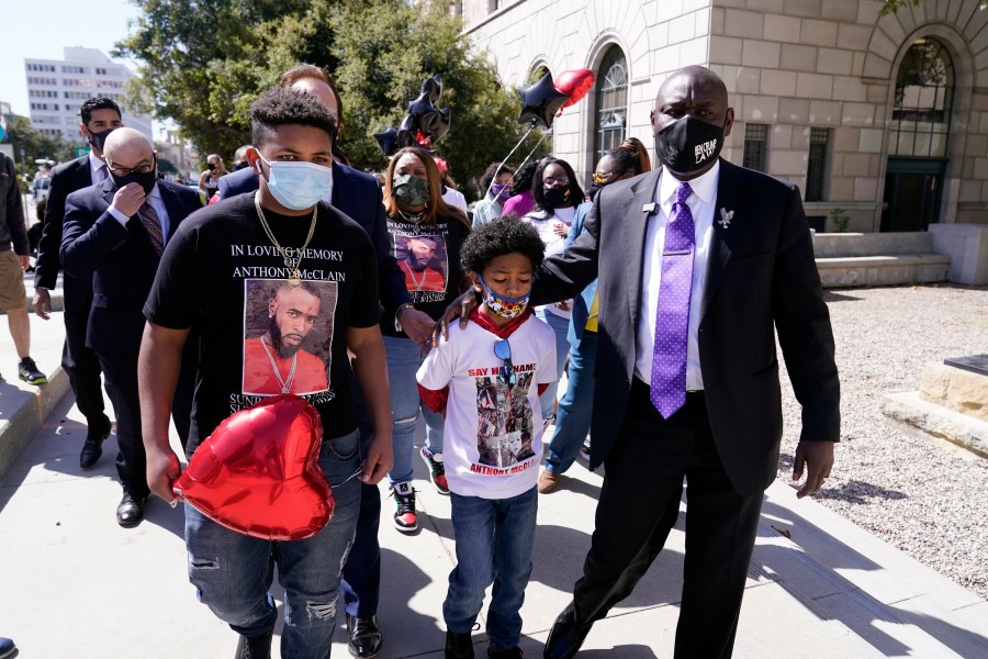 Attorney Ben Crump, right, walks with Anthony McClain's sons Anthony Jr., center, and Bryce, left, during a press conference announcing new developments on the McClain case on March 22, 2021, in Pasadena, Calif. (AP Photo/Marcio Jose Sanchez)