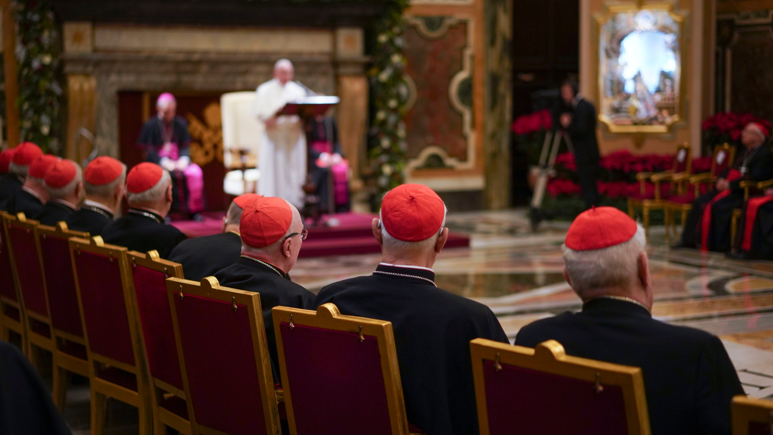 Cardinals listen as Pope Francis, background, delivers his Christmas greetings to the Roman Curia, in the Clementine Hall at the Vatican, Saturday, Dec. 21, 2019. Pope Francis has ordered pay cuts for Holy See employees, including slashing cardinals’ salaries by 10%. Francis in a letter made public by the Vatican on Wednesday, March 24, 2021, noted that the pandemic emergency “negatively impacted all sources of revenue” for the Holy See and Vatican City State. (AP Photo/Andrew Medichini, File)