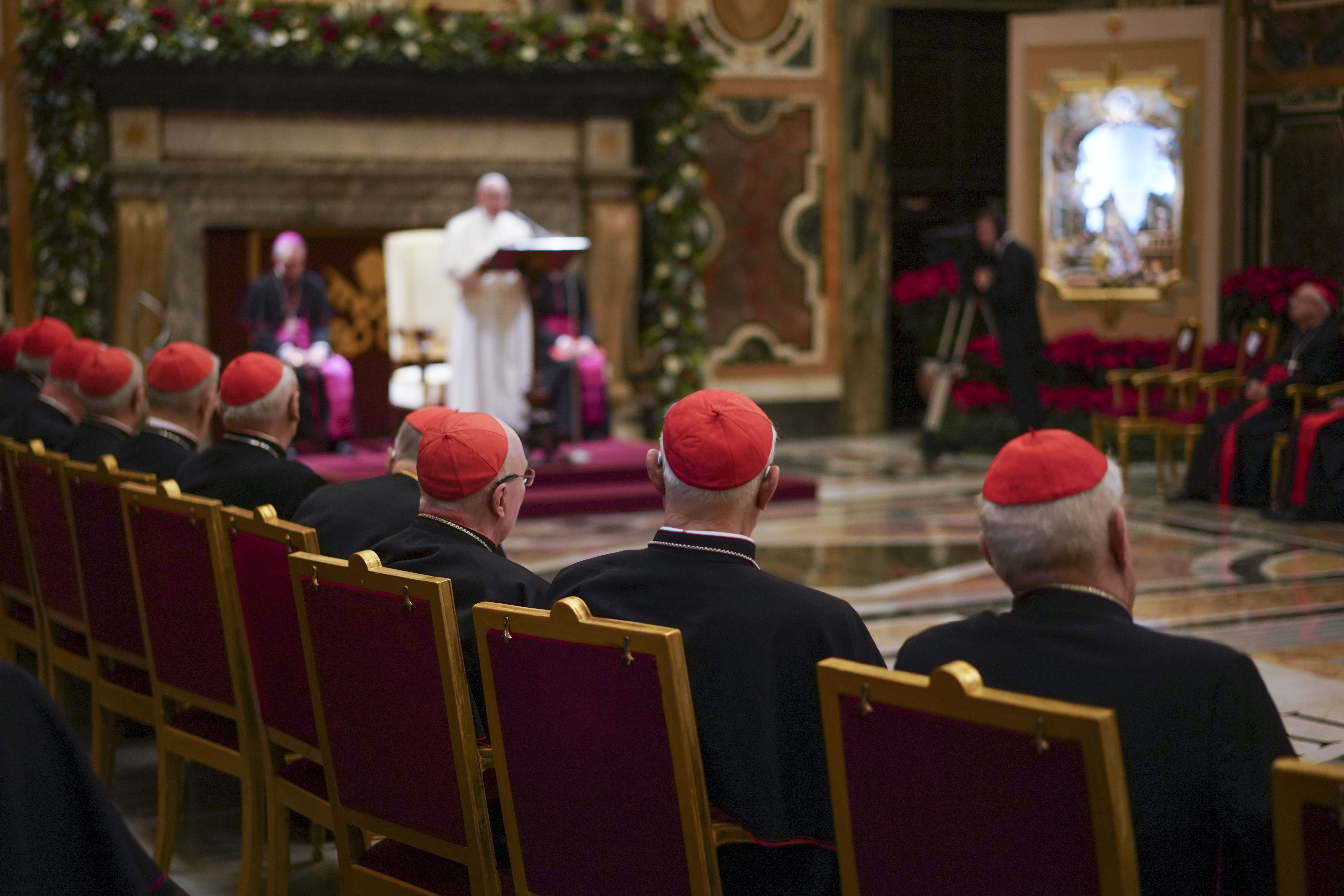 Cardinals listen as Pope Francis, background, delivers his Christmas greetings to the Roman Curia, in the Clementine Hall at the Vatican, Saturday, Dec. 21, 2019. Pope Francis has ordered pay cuts for Holy See employees, including slashing cardinals’ salaries by 10%. Francis in a letter made public by the Vatican on Wednesday, March 24, 2021, noted that the pandemic emergency “negatively impacted all sources of revenue” for the Holy See and Vatican City State. (AP Photo/Andrew Medichini, File)