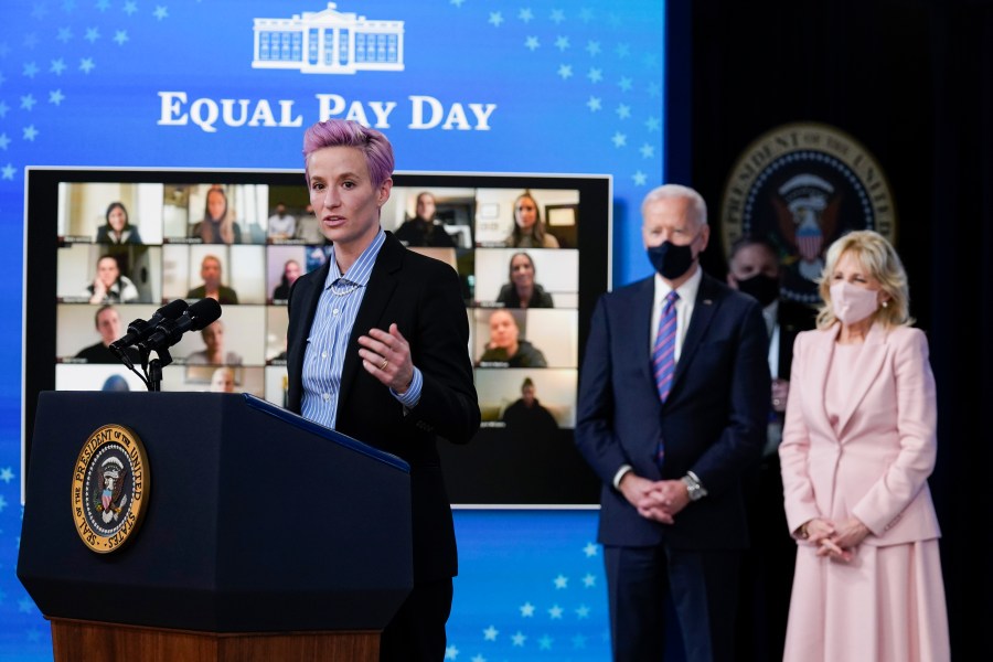 U.S. Soccer Women's National Team member Megan Rapinoe speaks as President Joe Biden and first lady Jill Biden look on during an event to mark Equal Pay Day in the Eisenhower Executive Office Building on the White House Campus on March 24, 2021. (Evan Vucci / Associated Press)