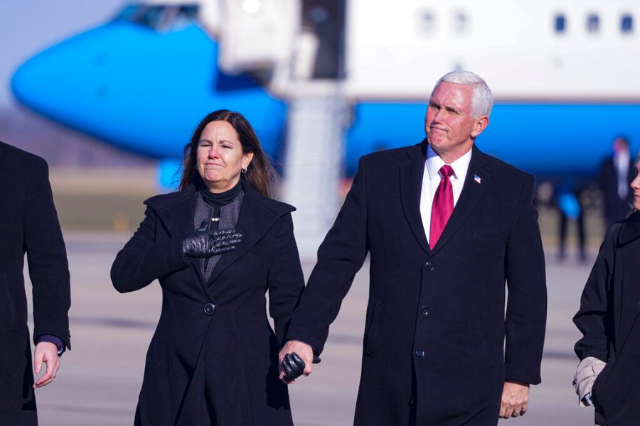 In this Jan. 20, 2021, file photo, former Vice President Mike Pence and his wife Karen walk from the plane to greet supporters after arriving back in his hometown of Columbus, Ind. (AP Photo/Michael Conroy, File)