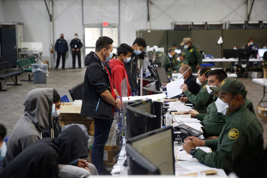 Migrants are processed at the intake area of the Donna Department of Homeland Security holding facility, the main detention center for unaccompanied children in the Rio Grande Valley, in Donna, Texas, on March 30, 2021. (AP Photo/Dario Lopez-Mills,Pool)