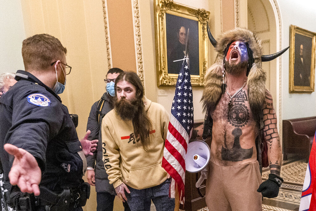 In this Wednesday, Jan. 6, 2021 file photo, supporters of President Donald Trump, including Jacob Chansley, right with fur hat, are confronted by U.S. Capitol Police officers outside the Senate Chamber inside the Capitol in Washington. (AP Photo/Manuel Balce Ceneta, File)