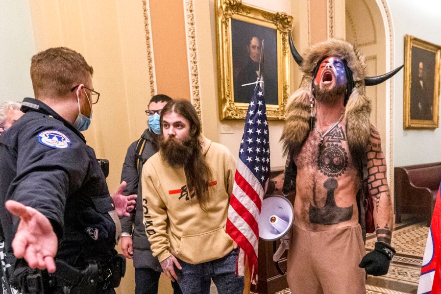 In this Wednesday, Jan. 6, 2021 file photo, supporters of President Donald Trump, including Jacob Chansley, right with fur hat, are confronted by U.S. Capitol Police officers outside the Senate Chamber inside the Capitol in Washington. (AP Photo/Manuel Balce Ceneta, File)