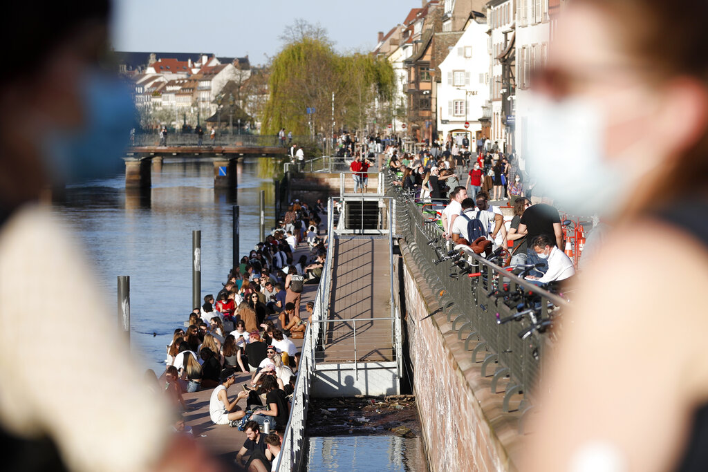 Youths gather along the Ill riverbanks in Strasbourg, eastern France, Wednesday, March 31, 2021. (AP Photo/Jean-Francois Badias)