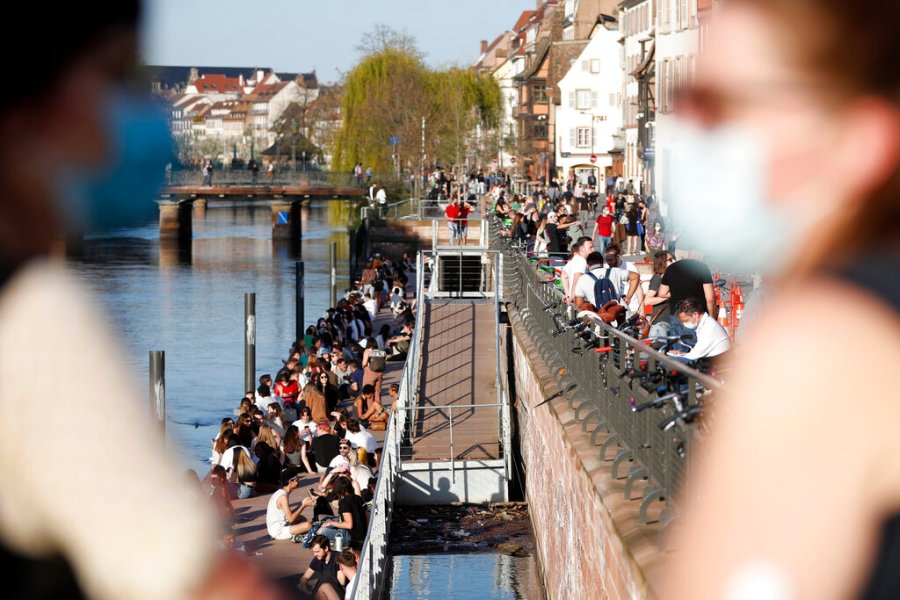 Youths gather along the Ill riverbanks in Strasbourg, eastern France, Wednesday, March 31, 2021. (AP Photo/Jean-Francois Badias)