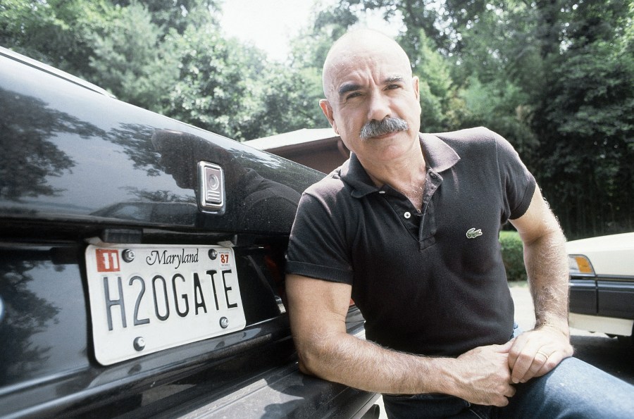 G. Gordon Liddy poses by the back of his car near his home in Fort Washington, Md. on Aug. 16, 1987. (Ira Schwarz/Associated Press)