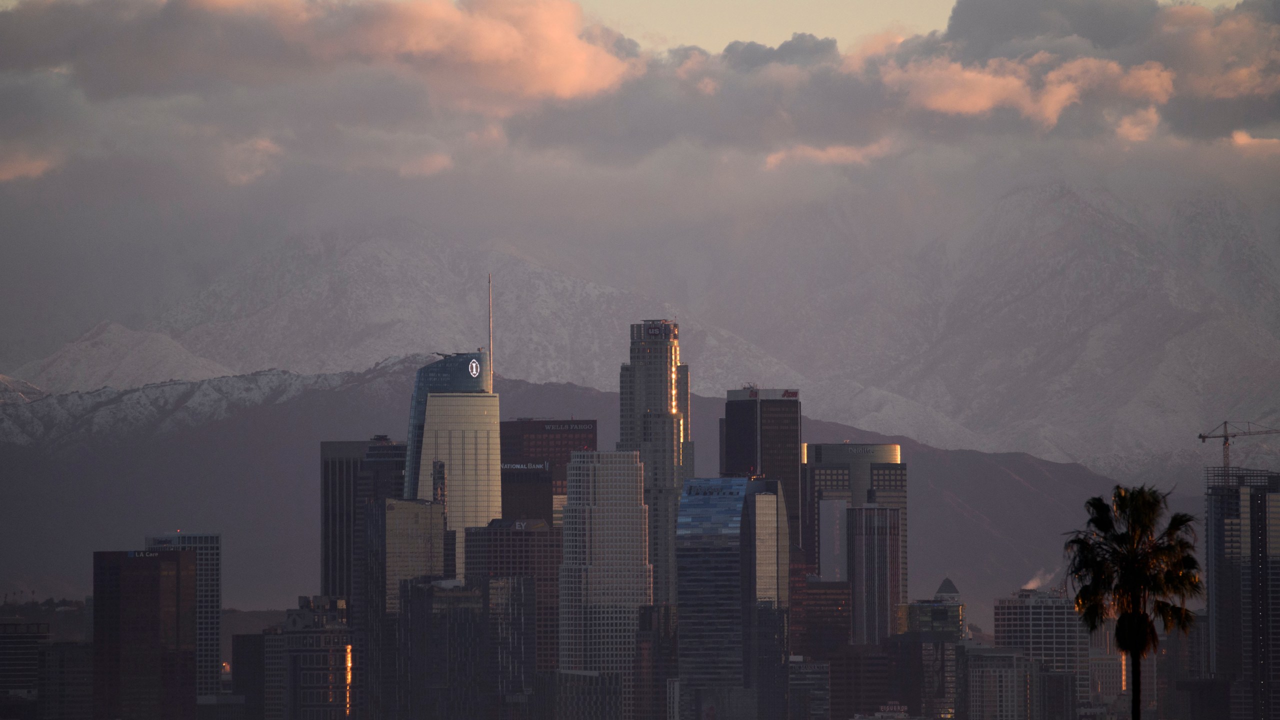 Snow-topped mountains stand behind the Los Angeles downtown skyline and Hollywood sign after sunrise following heavy rains as seen from the Kenneth Hahn State Recreation Area on December 29, 2020 in Los Angeles, California. (Patrick T. Fallon/AFP via Getty Images)