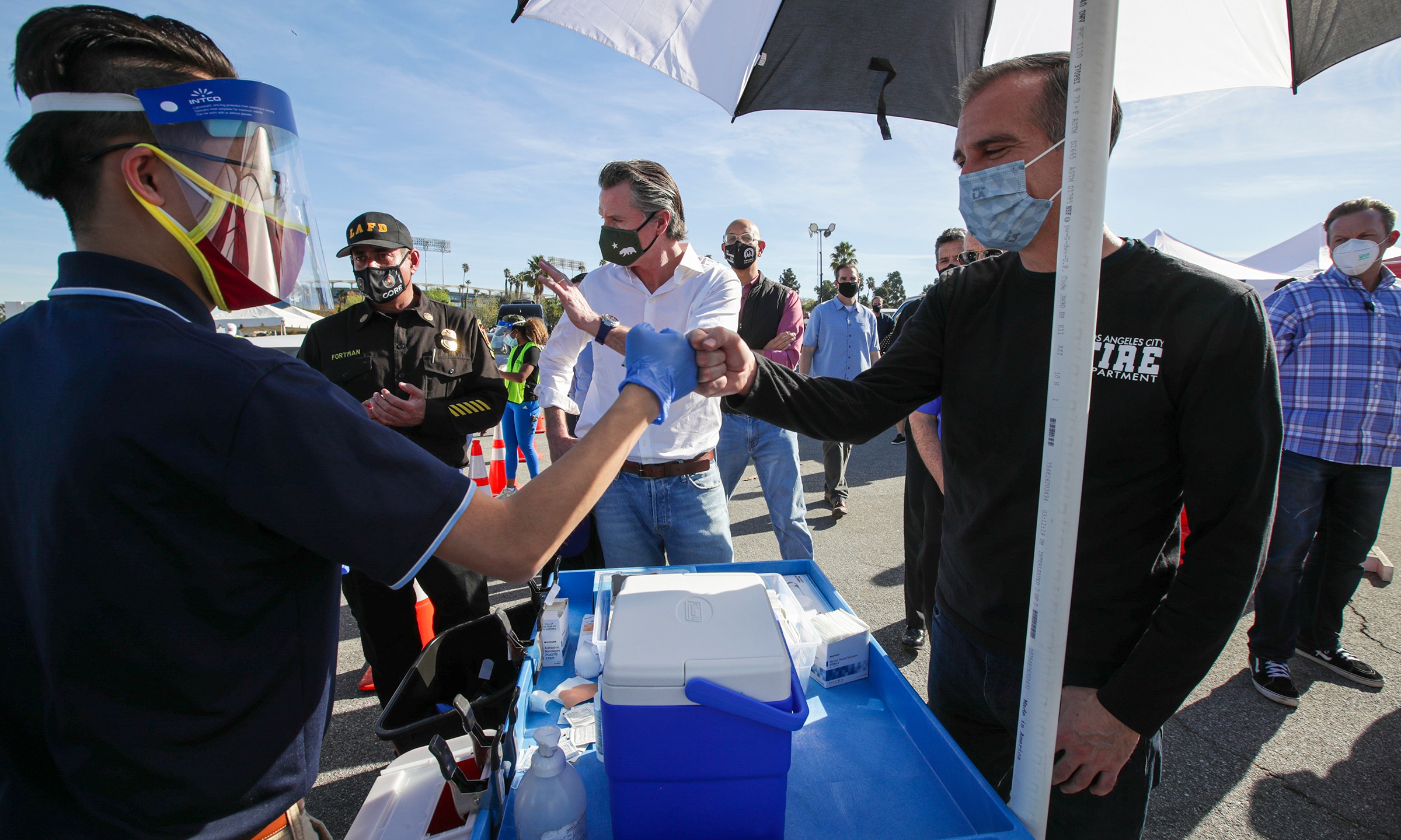 Los Angeles Mayor Eric Garcetti, at right, and California Governor Gavin Newsom, center, tour the mass COVID-19 vaccination site at Dodger Stadium on Jan. 15, 2021. (Irfan Khan / AFP / Getty Images)