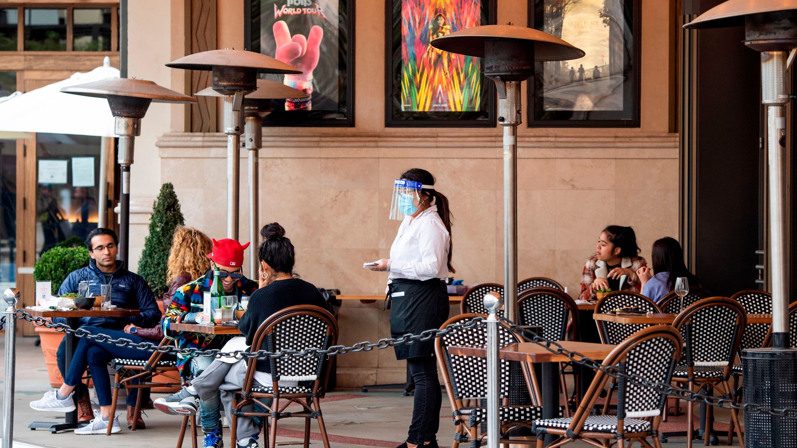 A waitress takes customers' orders in the outdoor seating area of a restaurant in Los Angeles on Jan. 28, 2021. (Valerie Macon / AFP / Getty Images)